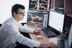A forex traders monitoring the stock exchange on his desktop